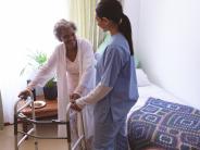An older adult being helped with walking 