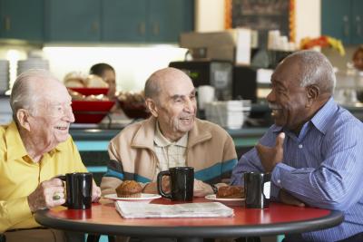 Mature Men sitting at a table having coffee or tea