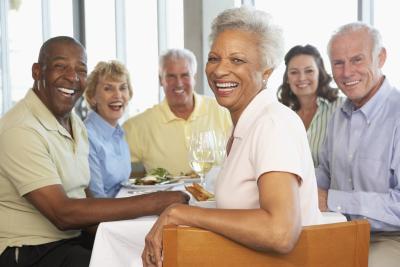 Mature Adults sitting at a table smiling 